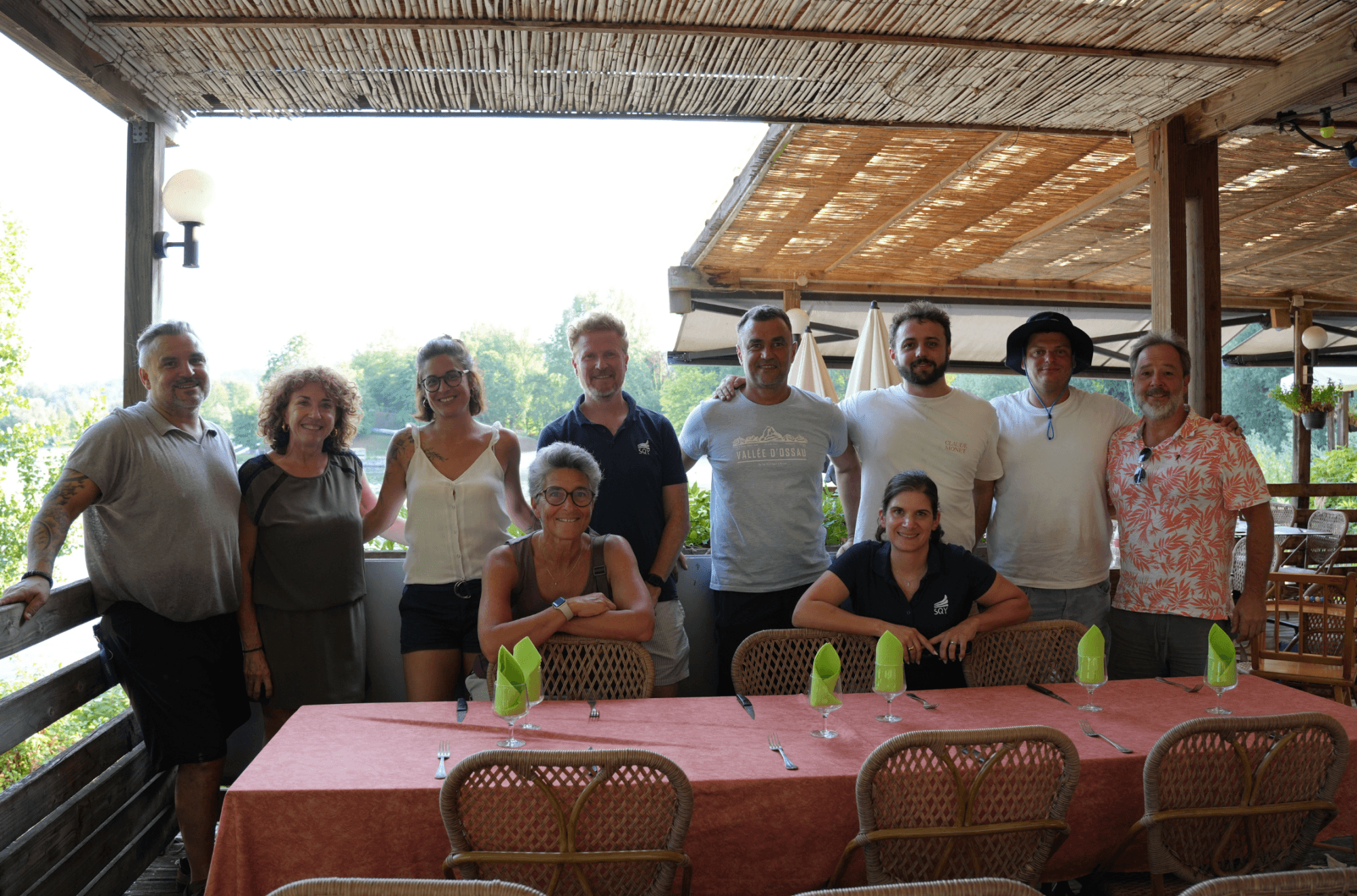 un groupe de 10 personnes se tient debout face camera avec le lac de baudreix en fond